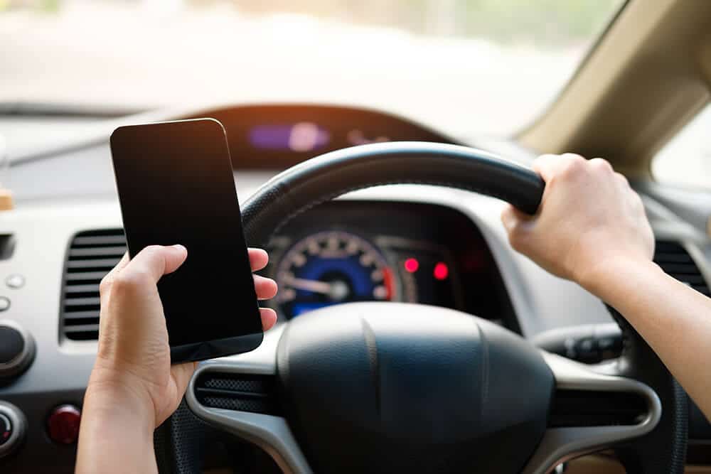 Person holding phone while driving