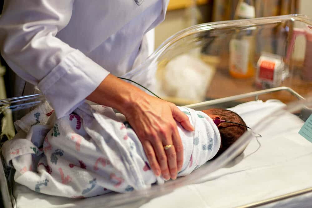 doctor checking on baby in nursery